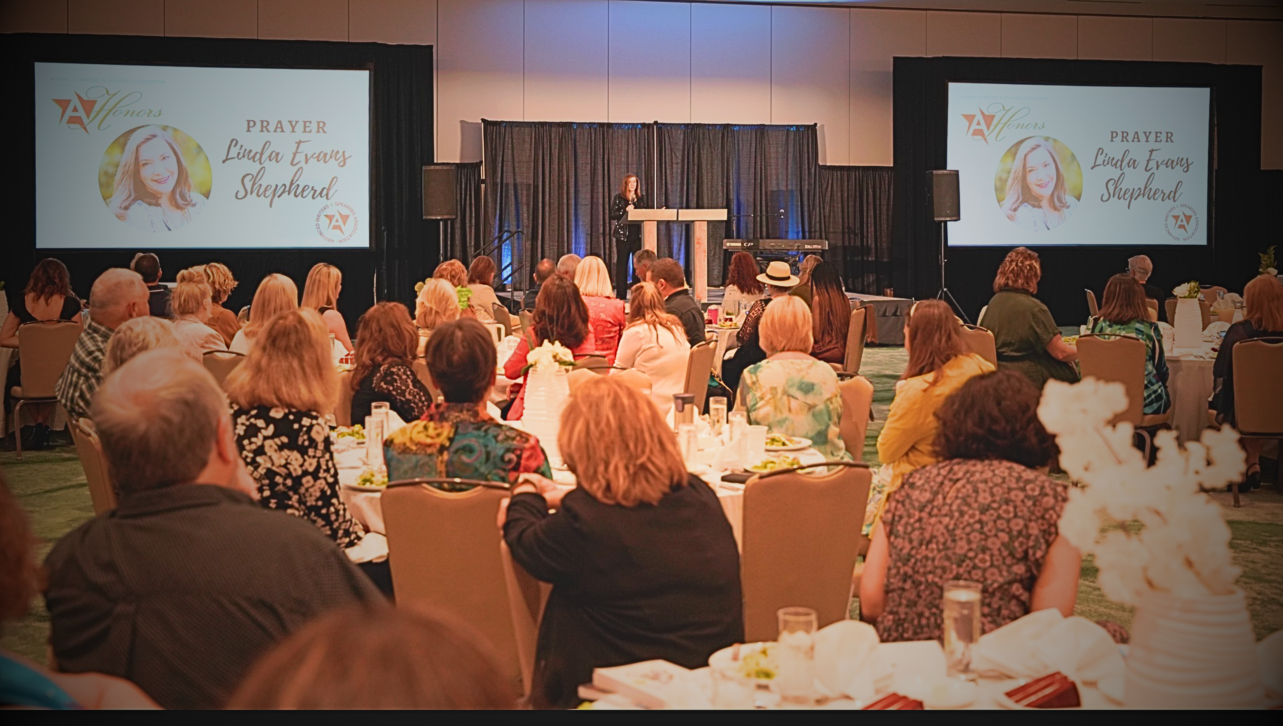 Banquet ballroom with Linda Evans Shepherd on the prayer-time screens